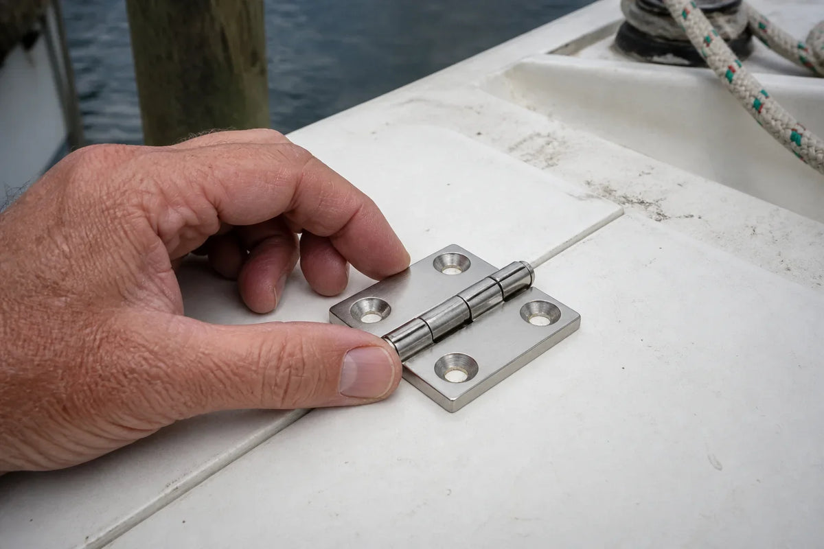 AI-generated technical illustration of a four-hole stainless boat hinge being dry-fitted across a hatch seam.