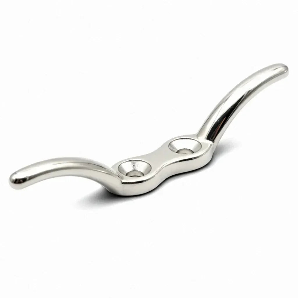 Mirror-polished 316 stainless steel clam cleat on a pure white background, showing precision-cast contours and countersunk mounting holes.