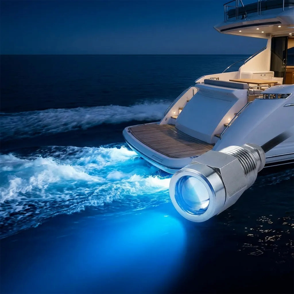Luxury yacht cruising at night with powerful blue underwater LED lights illuminating the wake from the transom.