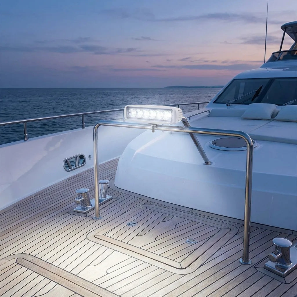 Lifestyle application showing the marine LED light bar mounted on a stainless steel yacht railing at dusk, providing high-intensity deck illumination.