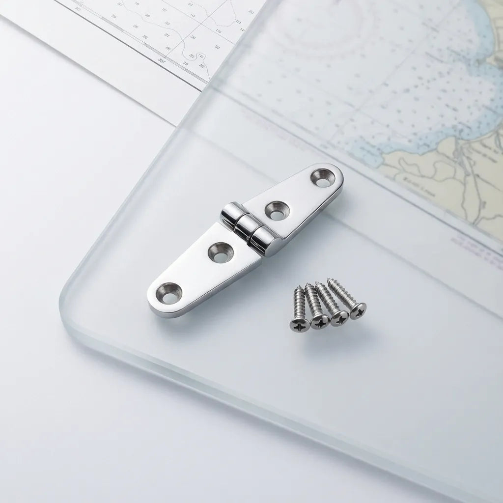 Detail shot of the boat hinge resting on a glass surface next to four stainless steel mounting screws and a marine navigation chart.