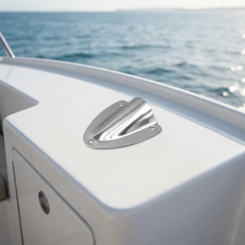 Mirror-polished stainless steel clamshell vent installed on a clean white fiberglass boat deck overlooking the ocean.