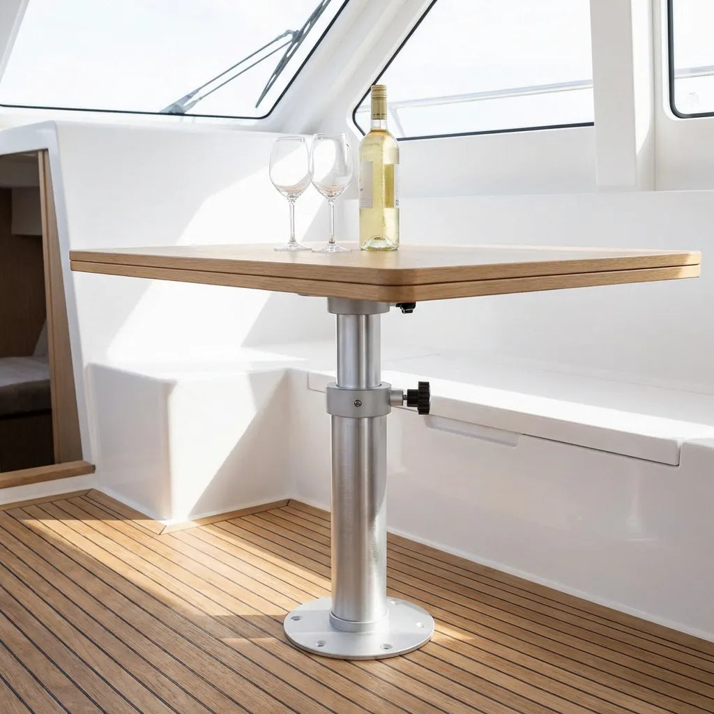 Lifestyle view of the adjustable pedestal installed on a luxury yacht deck with a wood-grain table and wine service, showcasing marine interior compatibility.